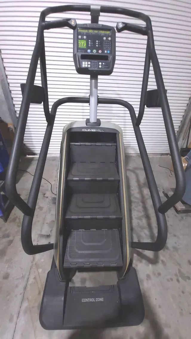 A stair climber is sitting in front of a garage door.
