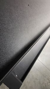 A close up of a black wall with a metal railing.