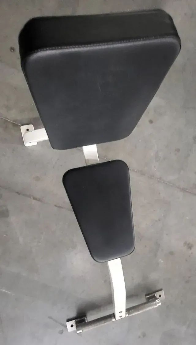 A black and white bench is sitting on a concrete floor.