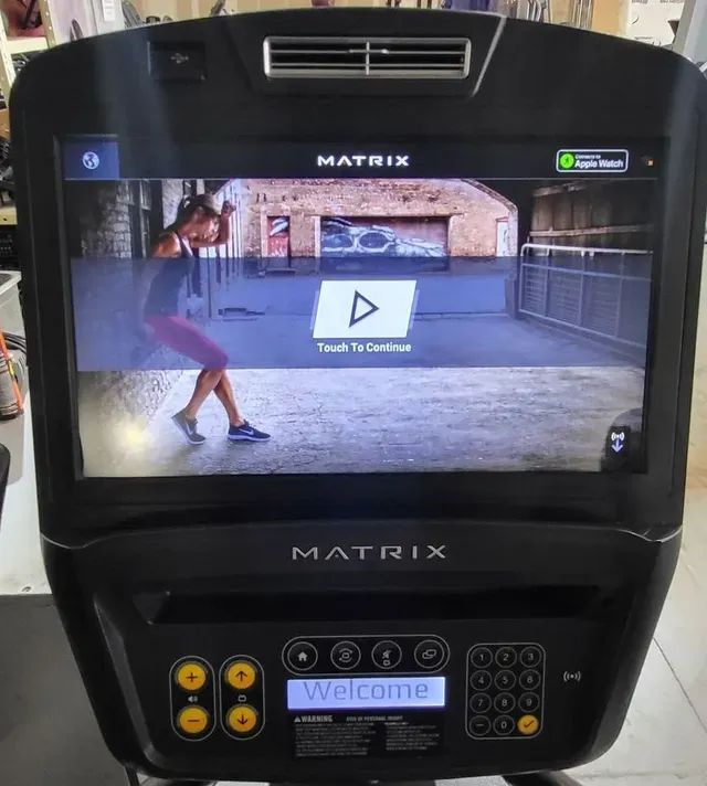 A matrix treadmill with a woman dancing on the screen.