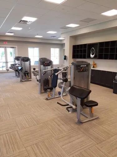 A large gym filled with lots of exercise equipment.