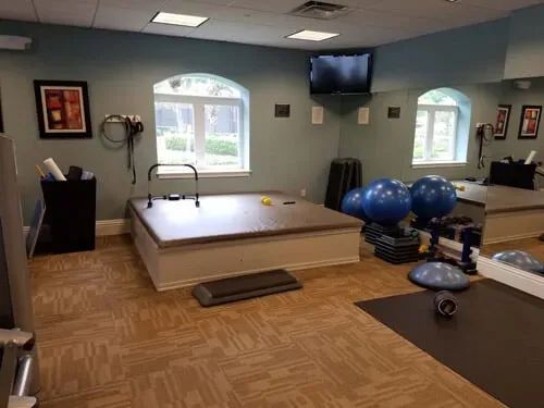 A gym with a lot of exercise equipment and a large mirror.