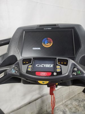 A treadmill with a large screen is sitting on a concrete floor.