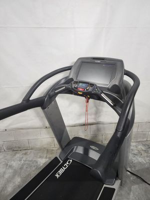 A treadmill is sitting in a warehouse next to a wall.