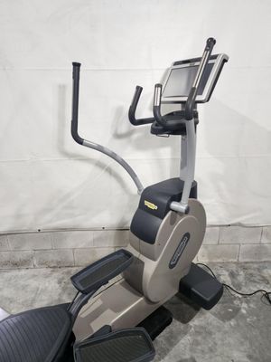 An elliptical machine is sitting in a garage next to a wall.
