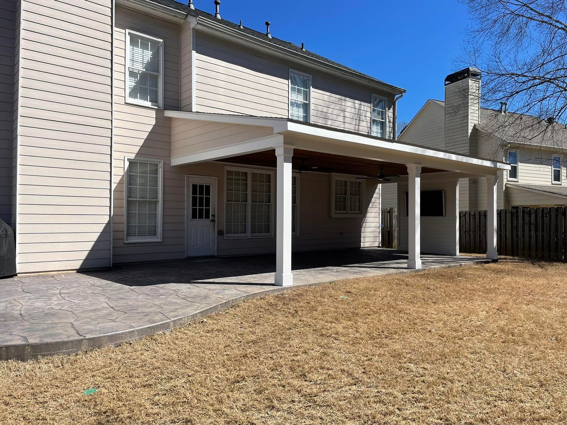 A large house with a covered patio in front of it.
