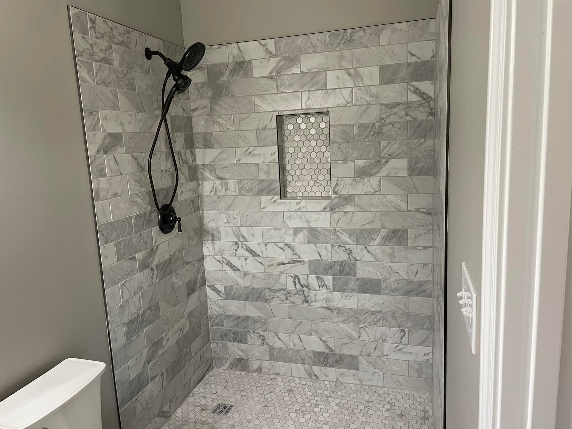 A bathroom with a walk in shower and a toilet.