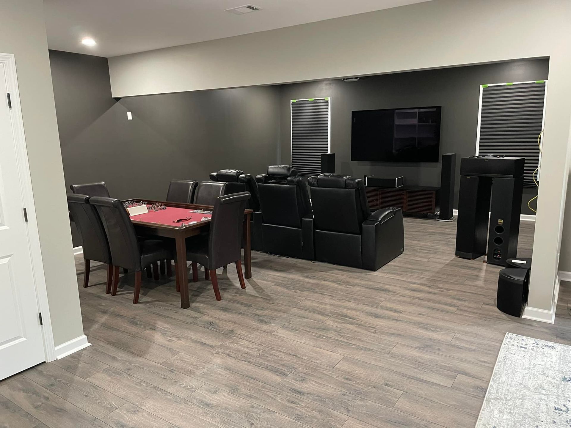 A living room with a table and chairs and a flat screen tv.