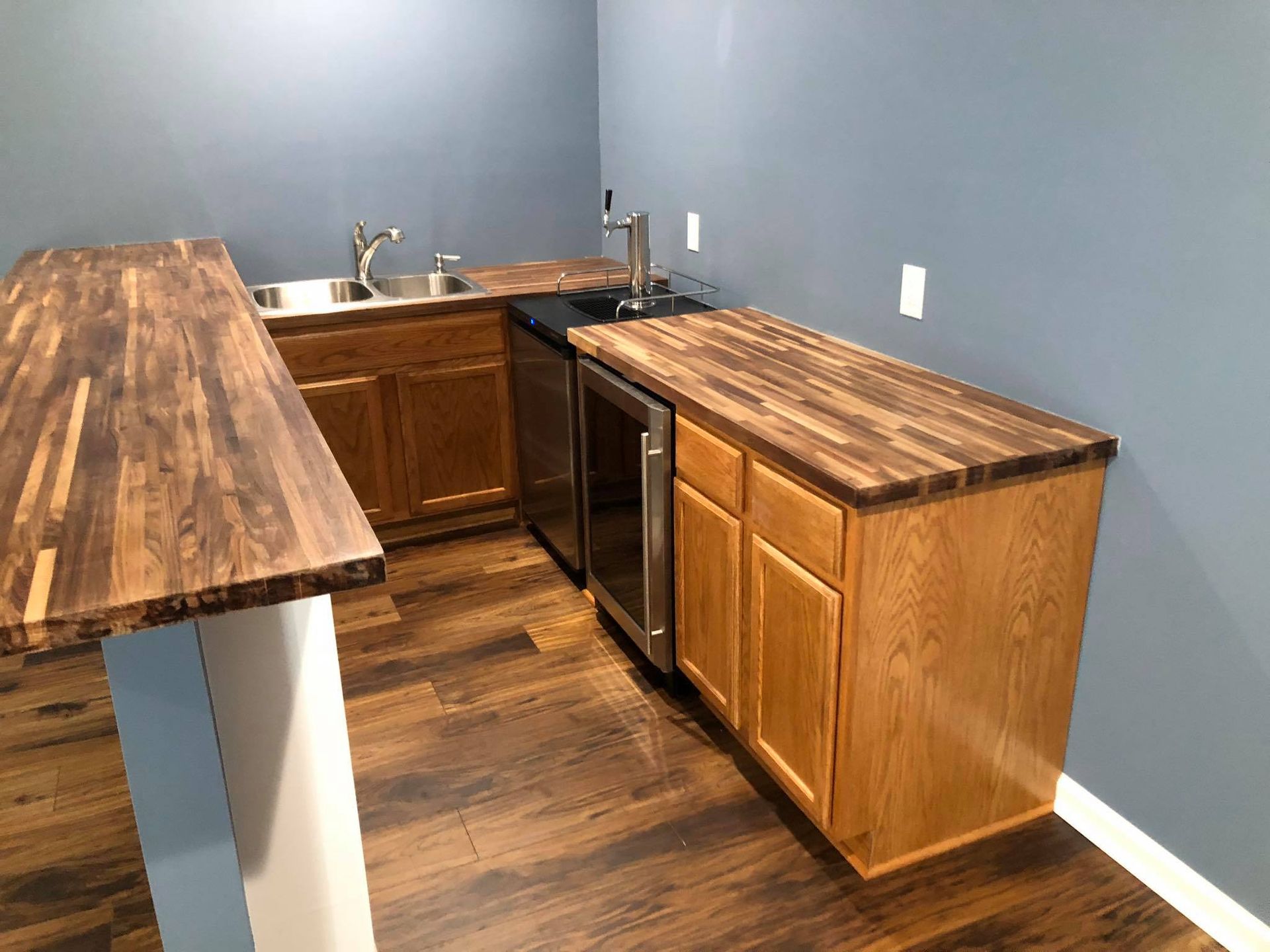 A kitchen with wooden cabinets , a sink , and a refrigerator.