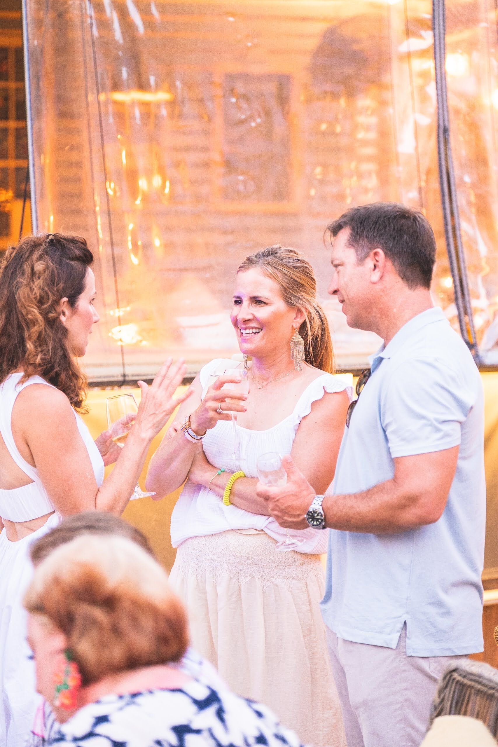 A group of people are standing around a table talking to each other.