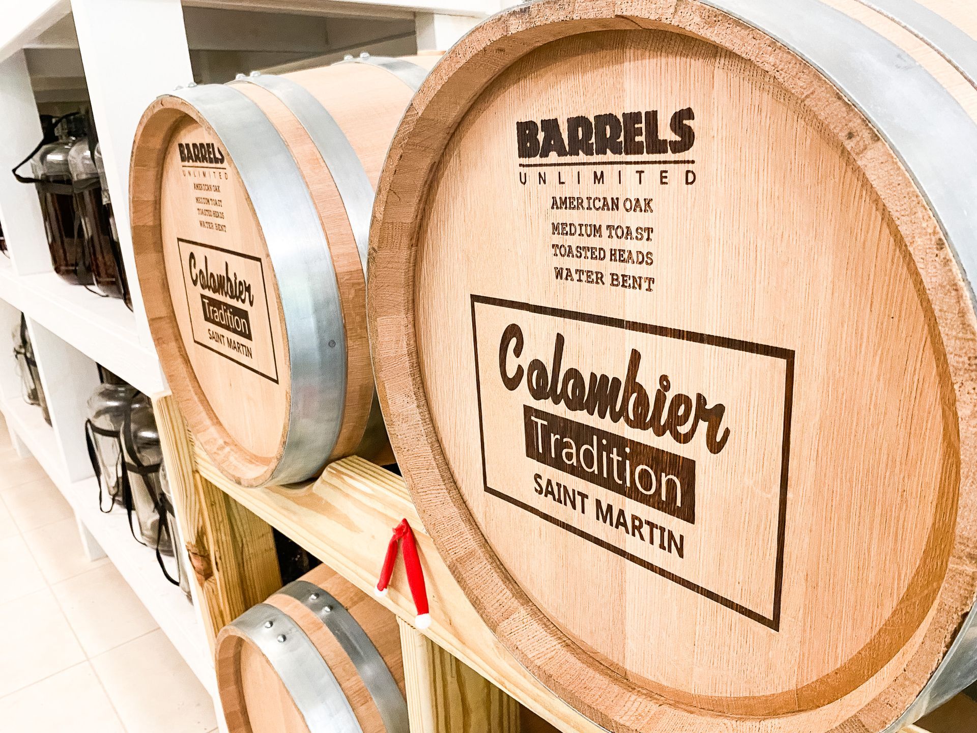 A row of wooden barrels sitting on top of a wooden shelf.