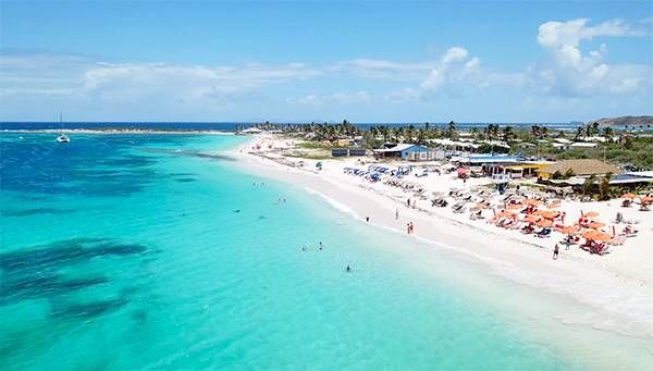 An aerial view of a beach with a lot of people on it.