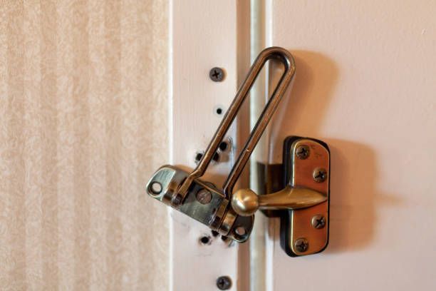 A close up of a door latch on a white door.
