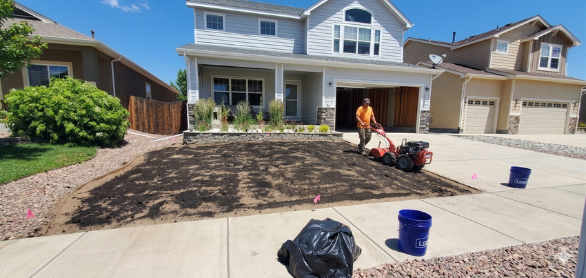 Front yard with a freshly tilled garden bed in front of a two-story suburban house