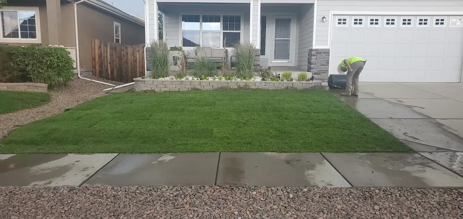 Suburban house front yard with green lawn, stone walkway, and attached garage