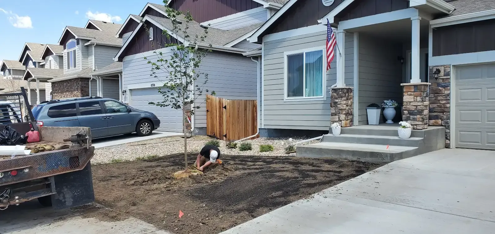 Suburban house exterior with a driveway, front porch, and a parked car