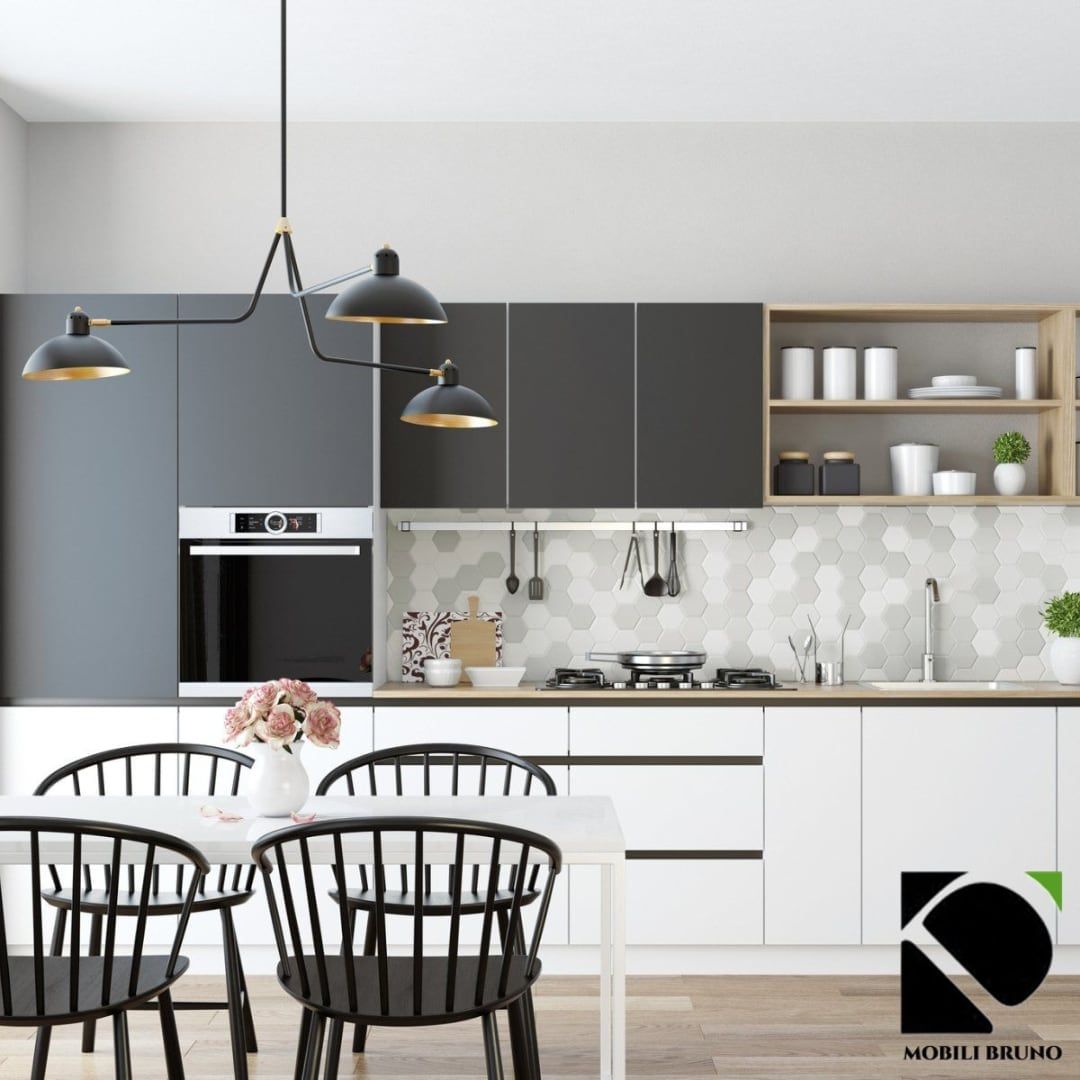 Cucina moderna con mobili grigi e bianchi, lampade a sospensione nere e sedie nere.