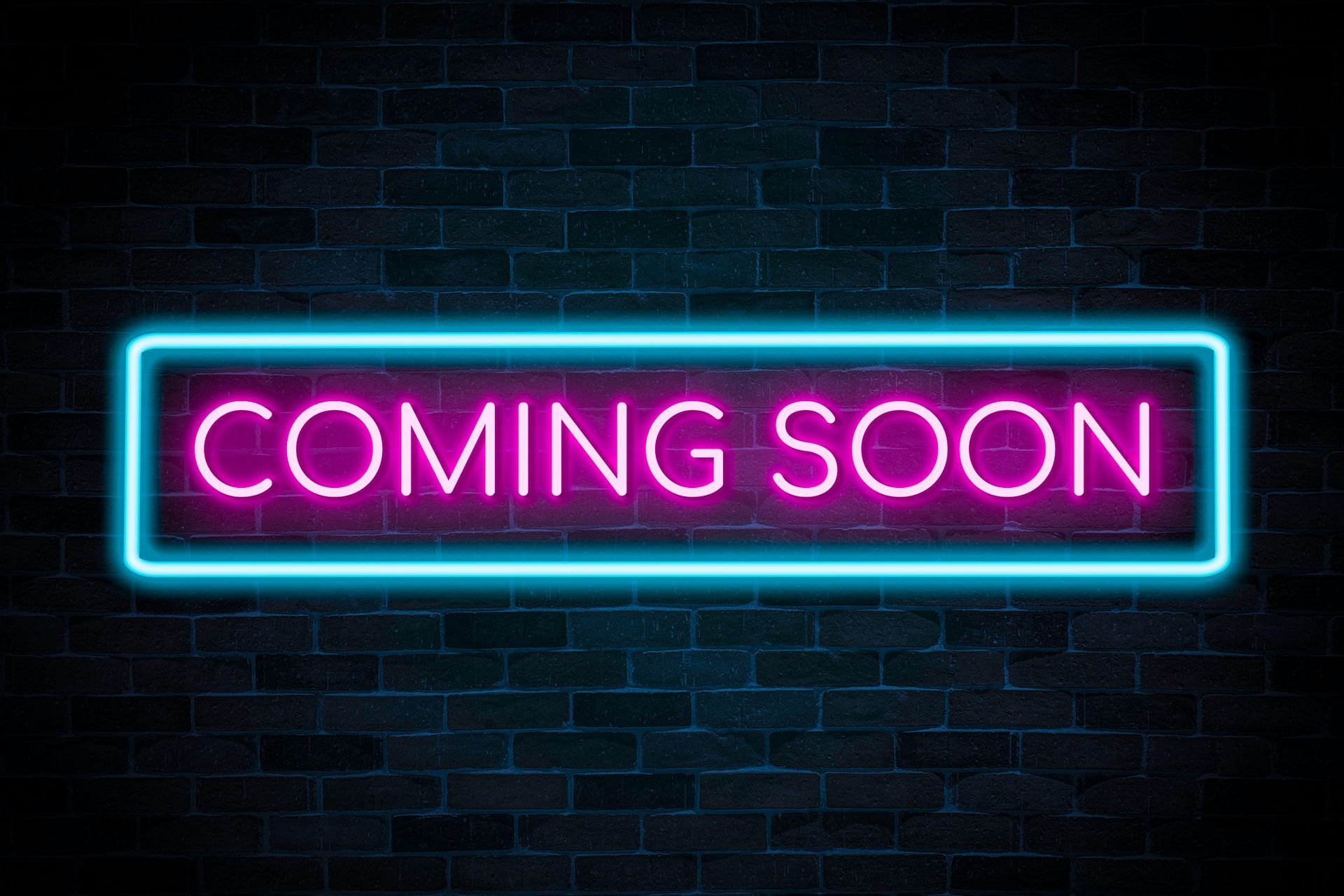 Neon sign on a brick wall reads COMING SOON in pink with a teal border.