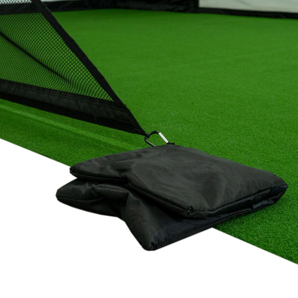 Golf simulator room with screen, green turf, TV, and black projector enclosure.