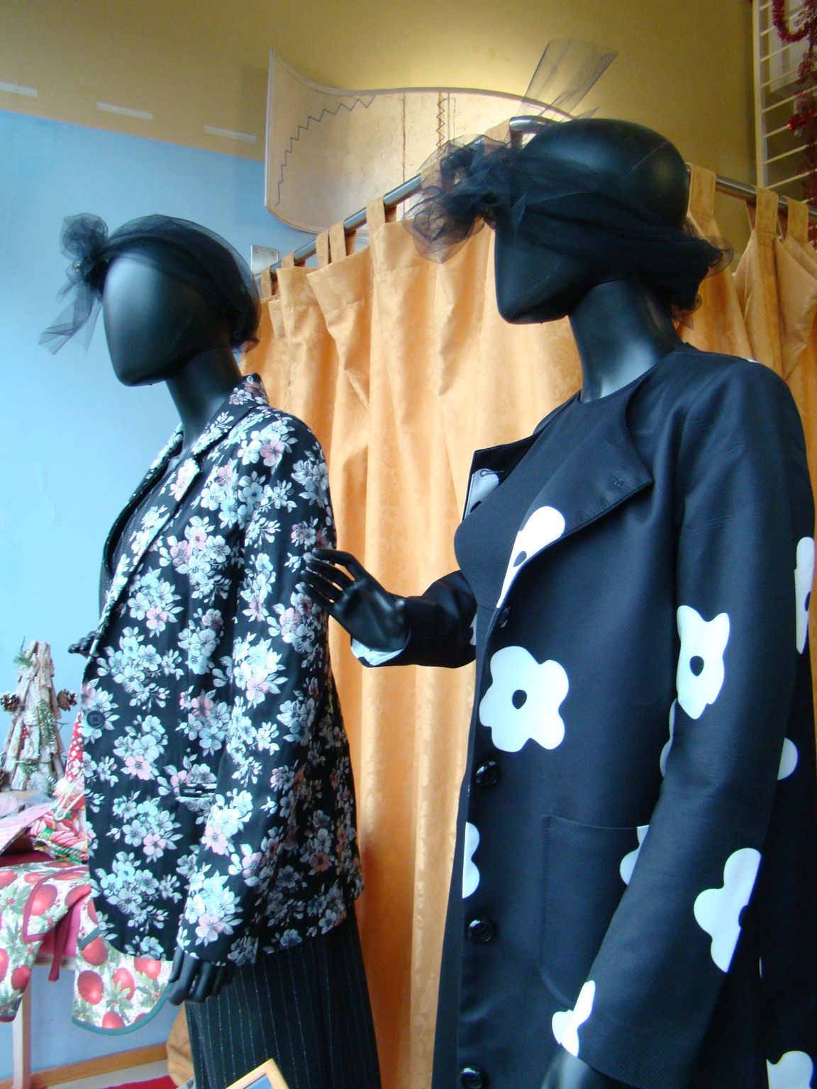 Due manichini che indossano giacche floreali bianche e nere