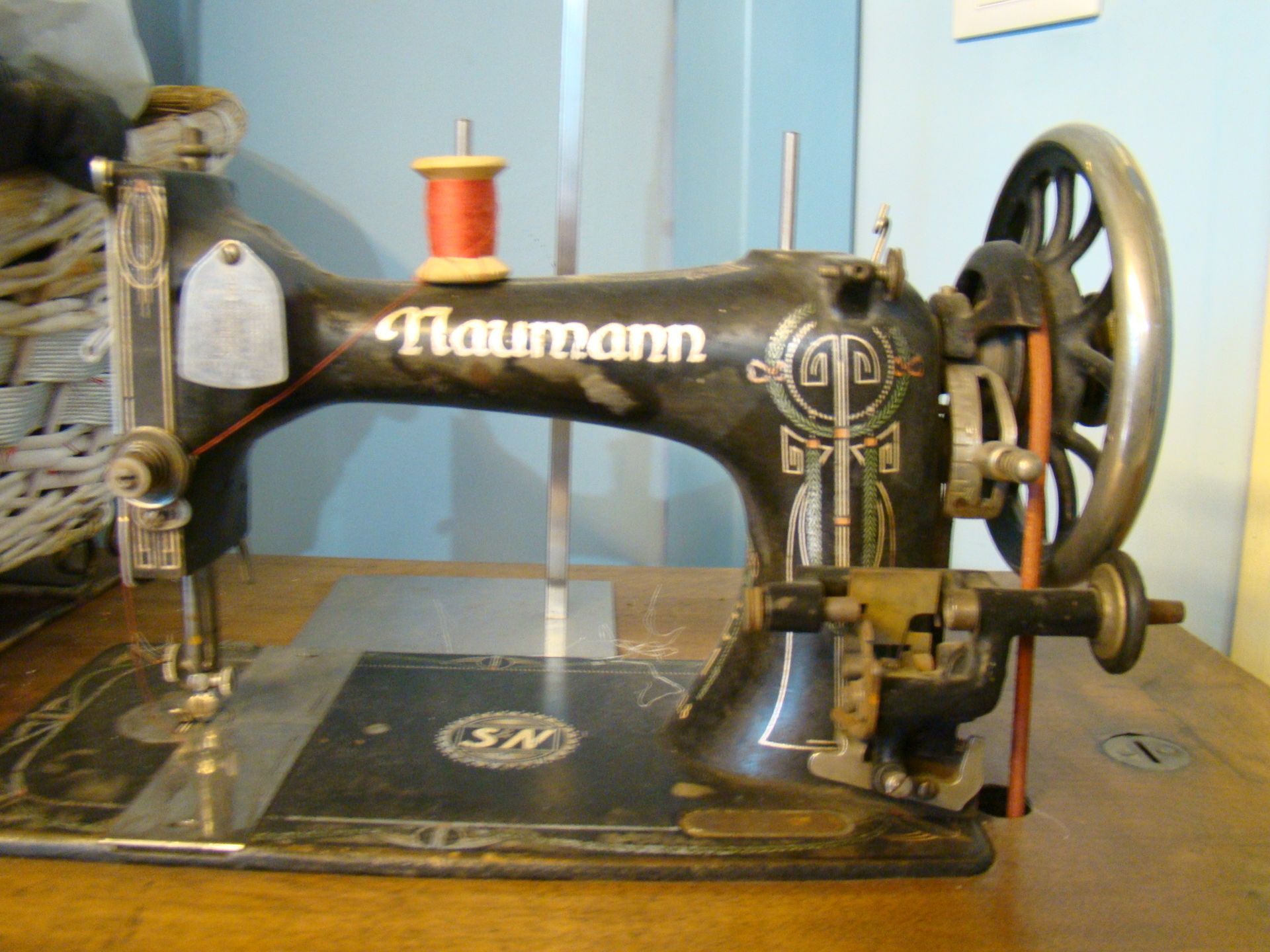 Una macchina da cucire antica realizzata da Haumann è appoggiata su un tavolo di legno