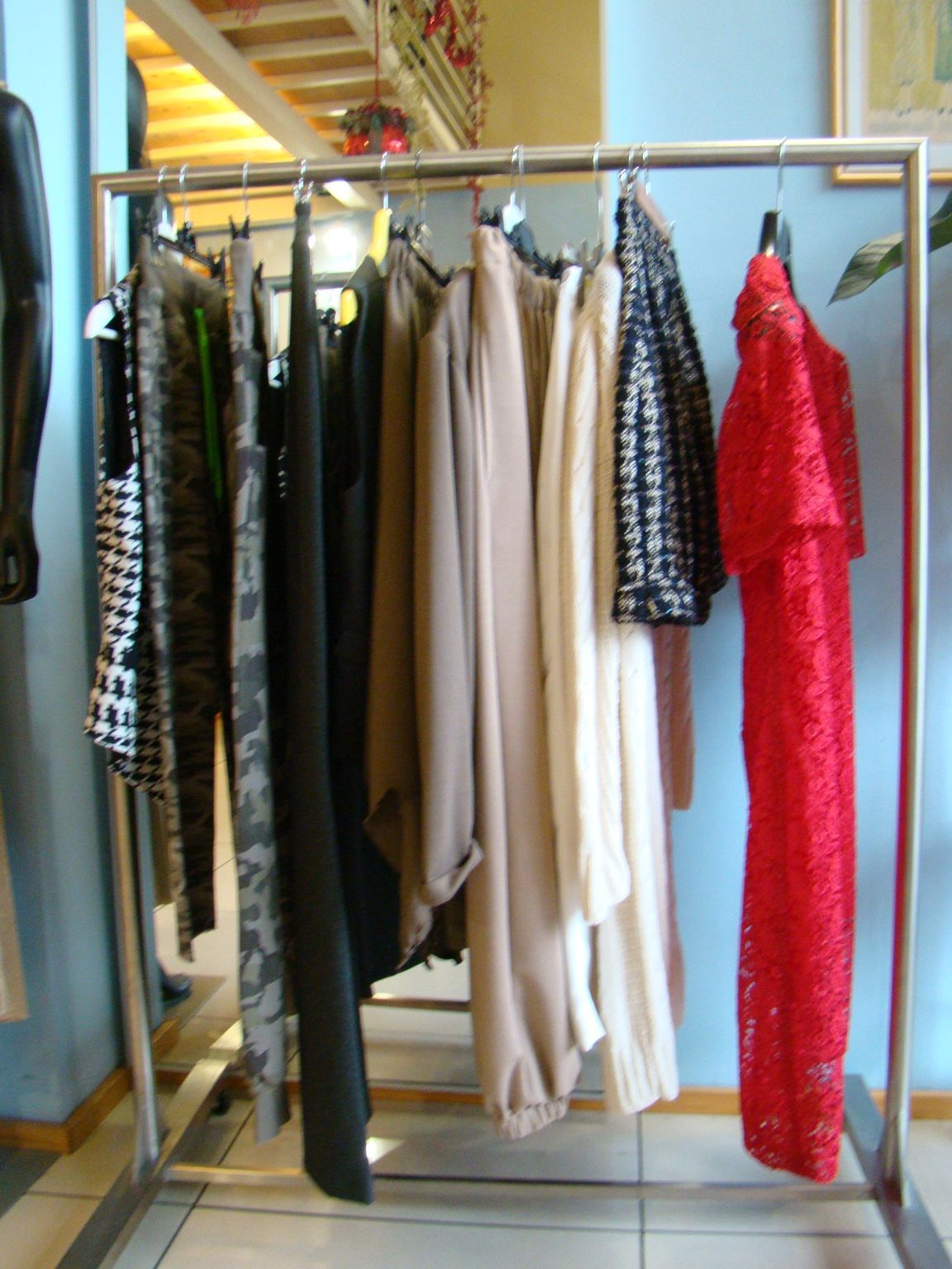 Uno scaffale pieno di vestiti, tra cui un vestito rosso