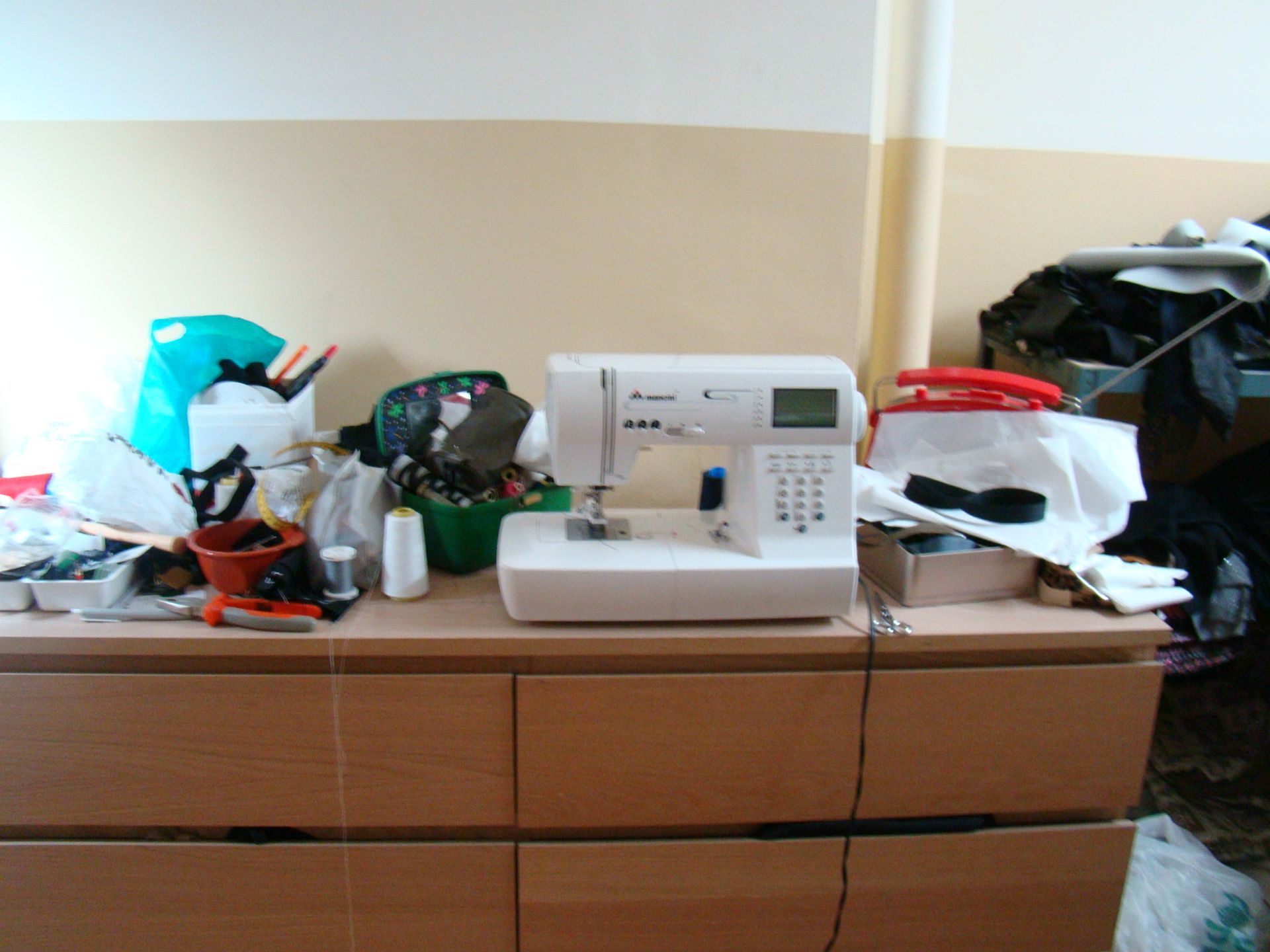 Una macchina da cucire è appoggiata su un tavolo di legno