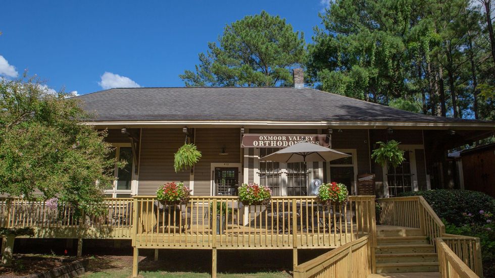 A large house with a large deck and stairs leading to it.