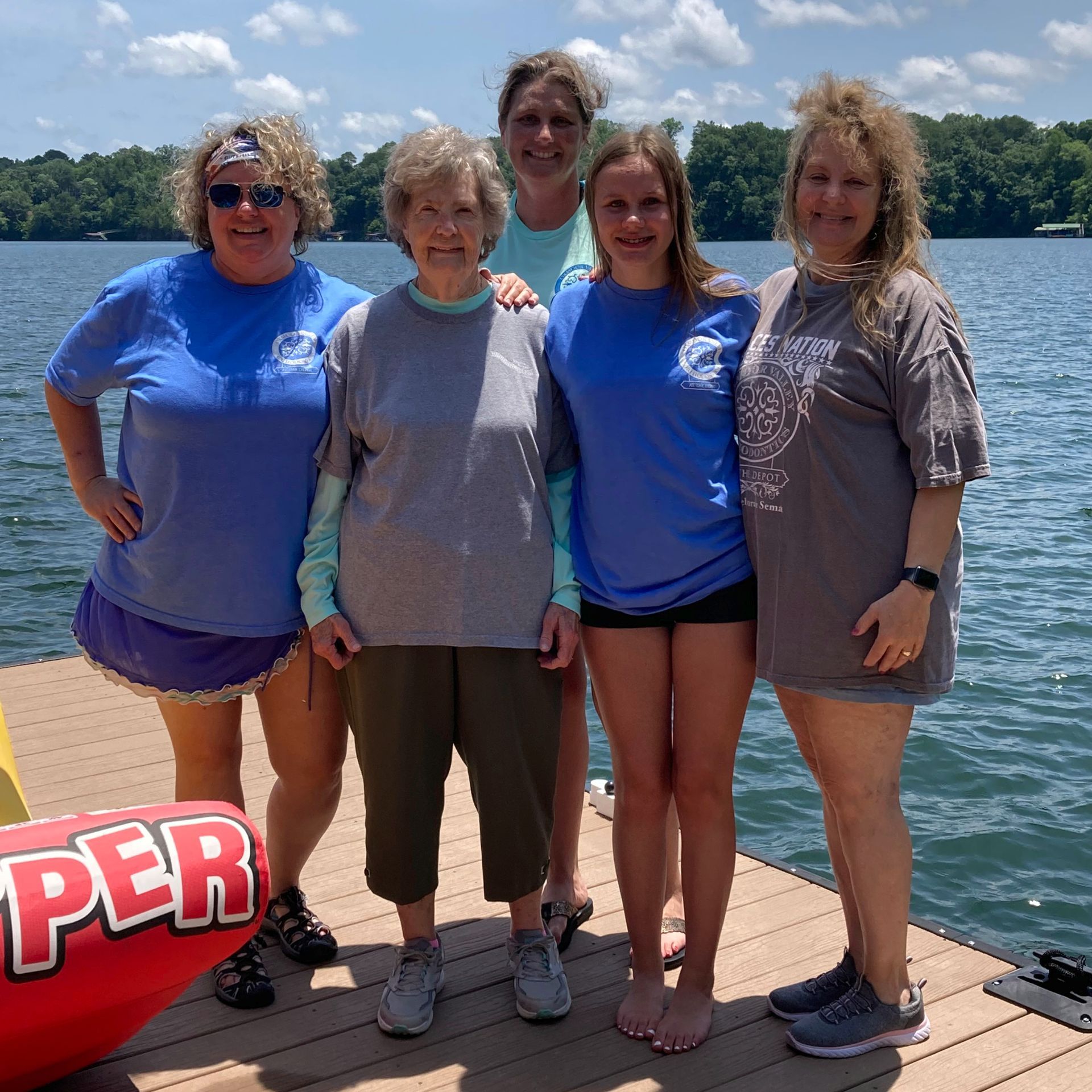 A group of women standing on a dock next to a super raft