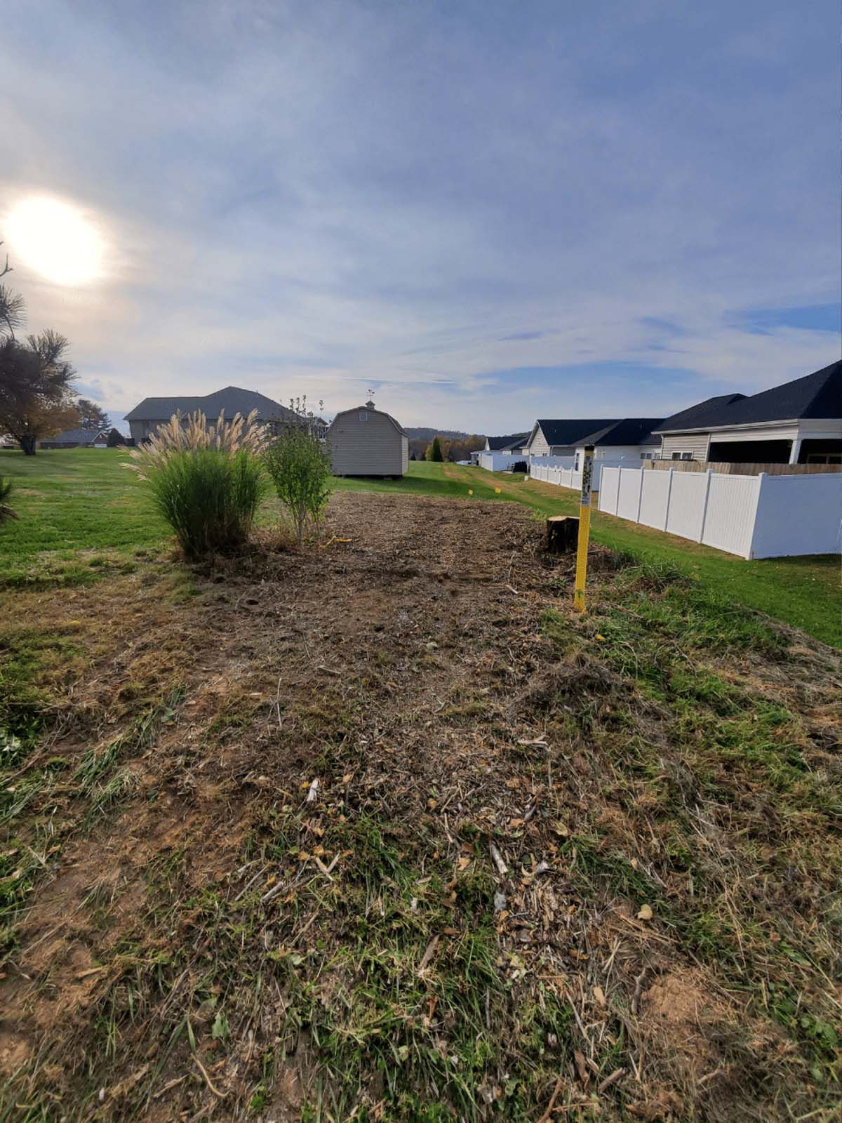 A dirt road leading to a house in a residential area.