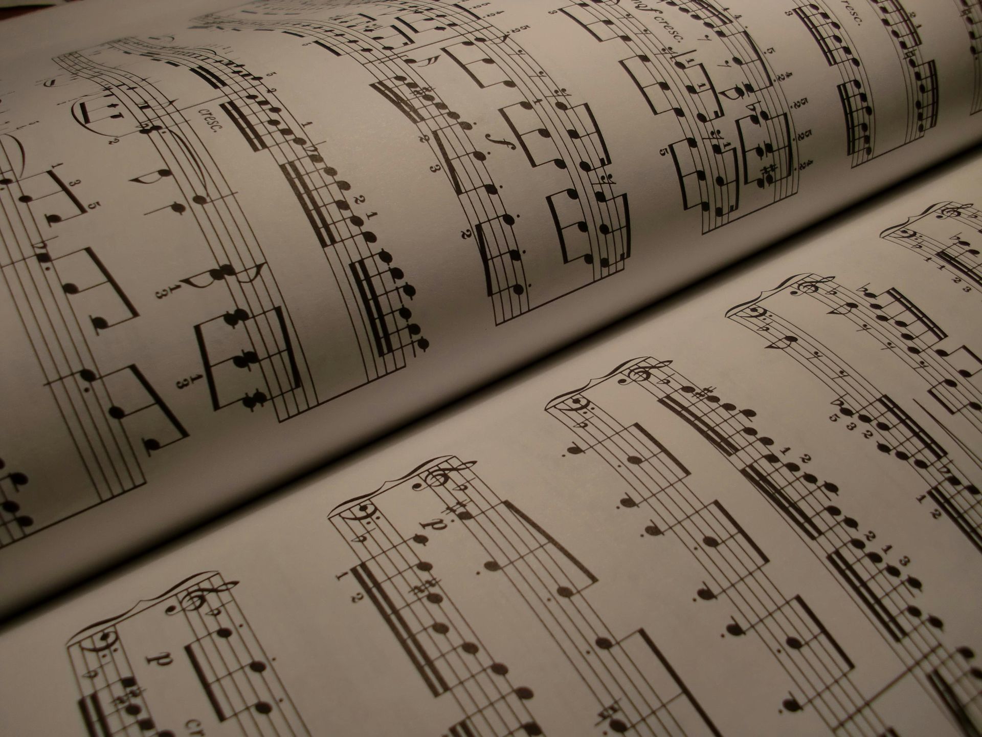 Open book displaying printed musical notes on white pages.