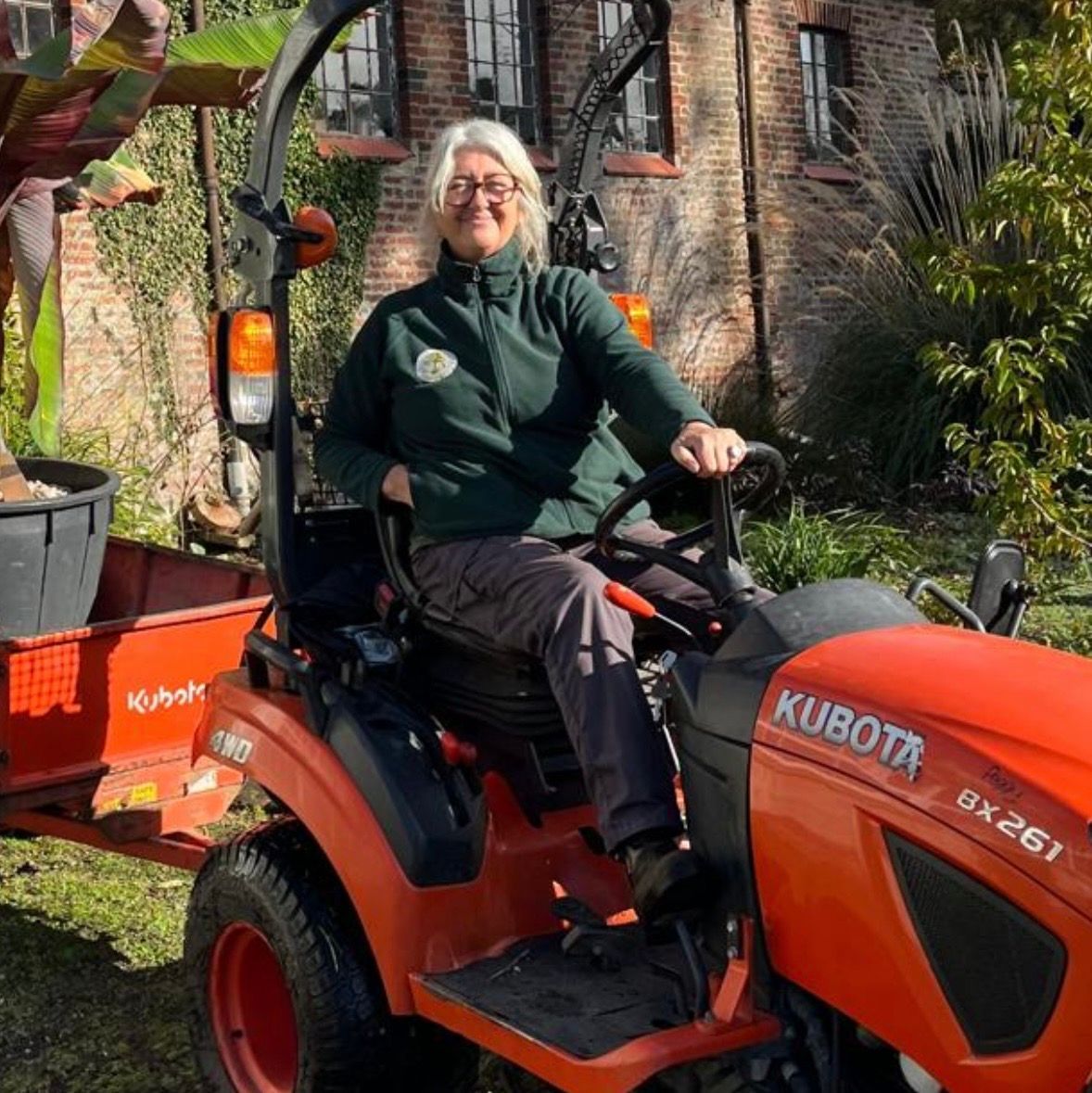 Women sitting on a red tractor.