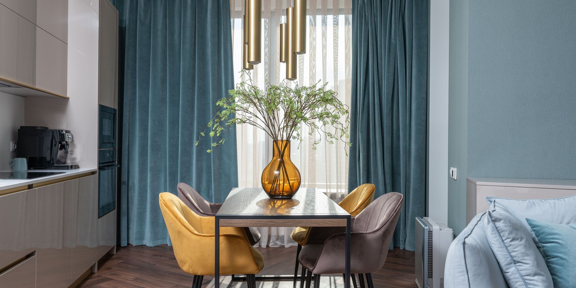 A dining room with a table and chairs and a vase of flowers on it.