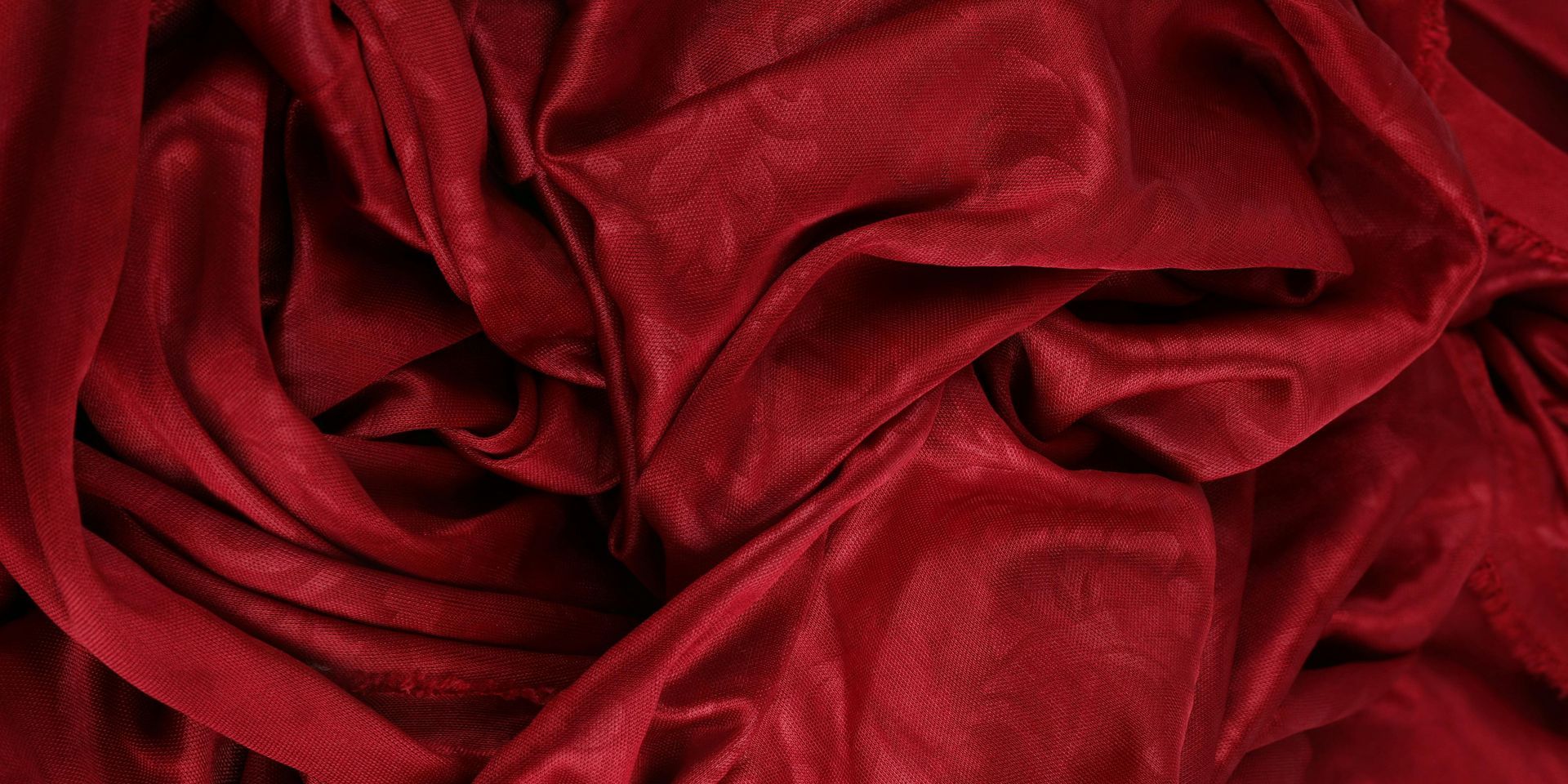 Red velvet fabric, draped and textured with highlights and shadows.