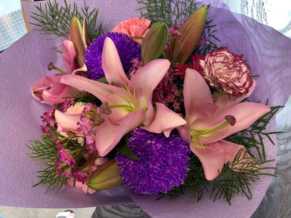 A Bouquet Of Pink And Purple Flowers Wrapped In Purple Paper — The House of Flowers In Kirwan, QLD