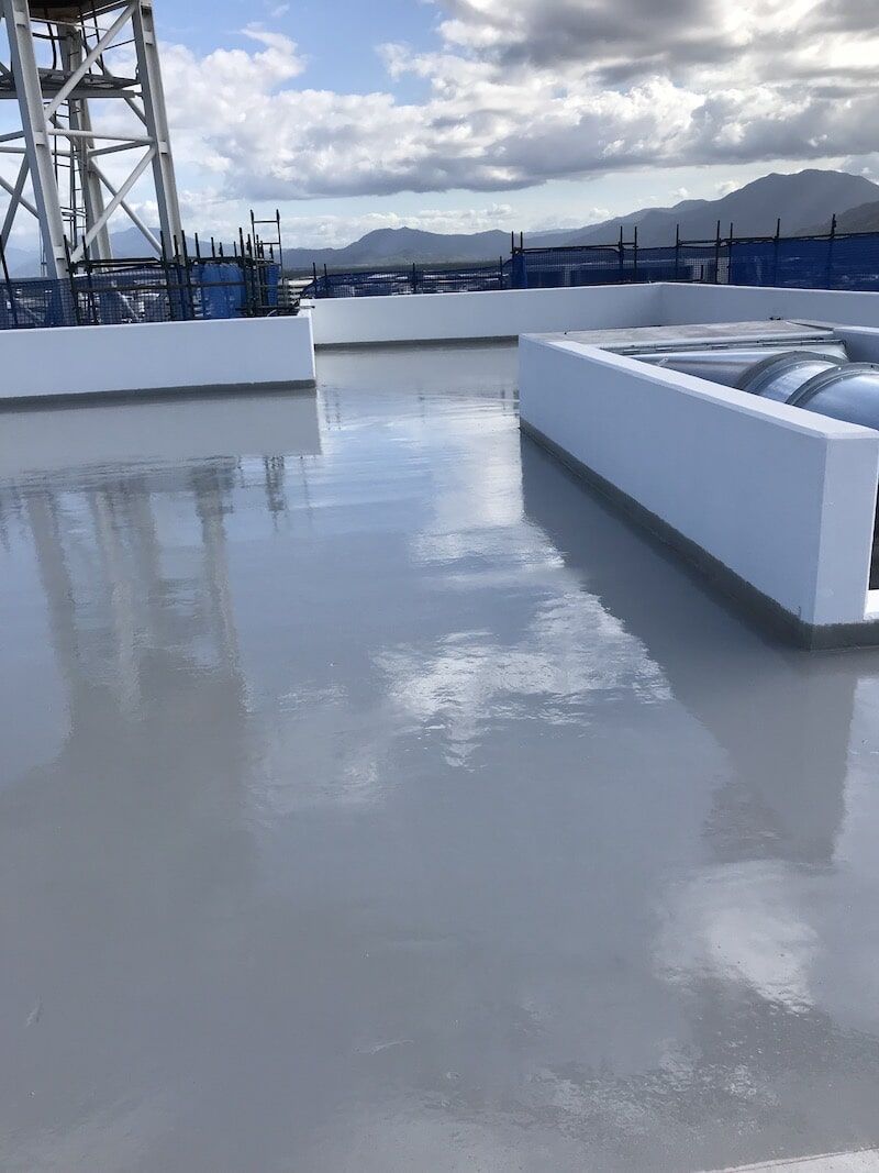 A Rooftop With A Tower In The Background And A Reflection Of Clouds In The Water — Eldred Waterproofing In Whitfield, QLD