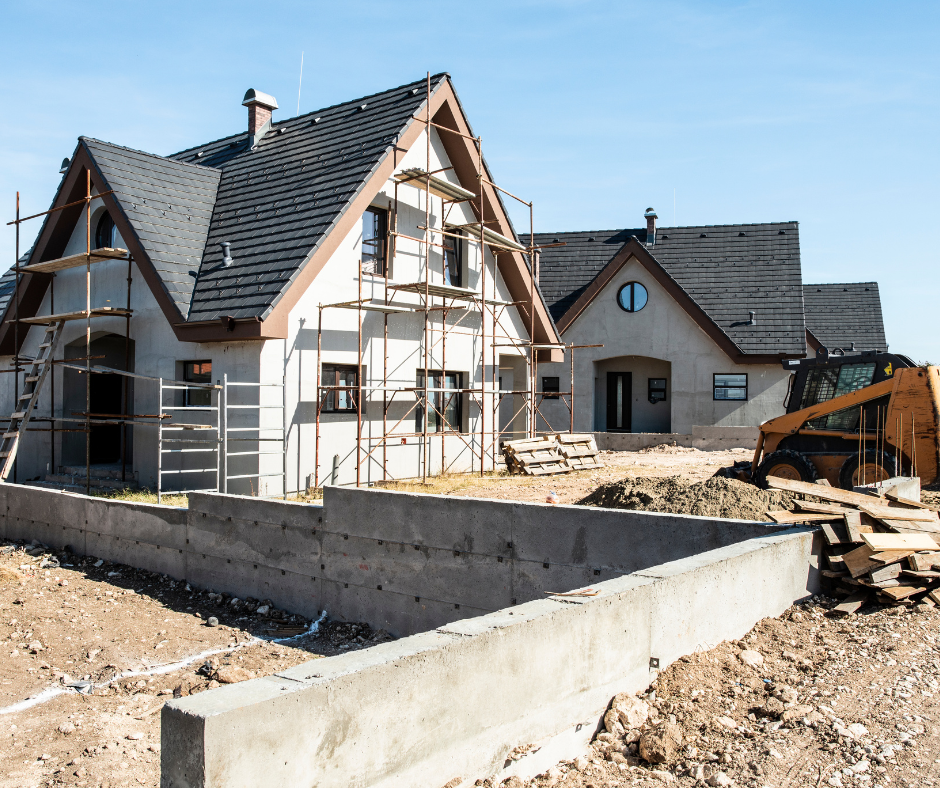 A house that is being built with a bulldozer in front of it