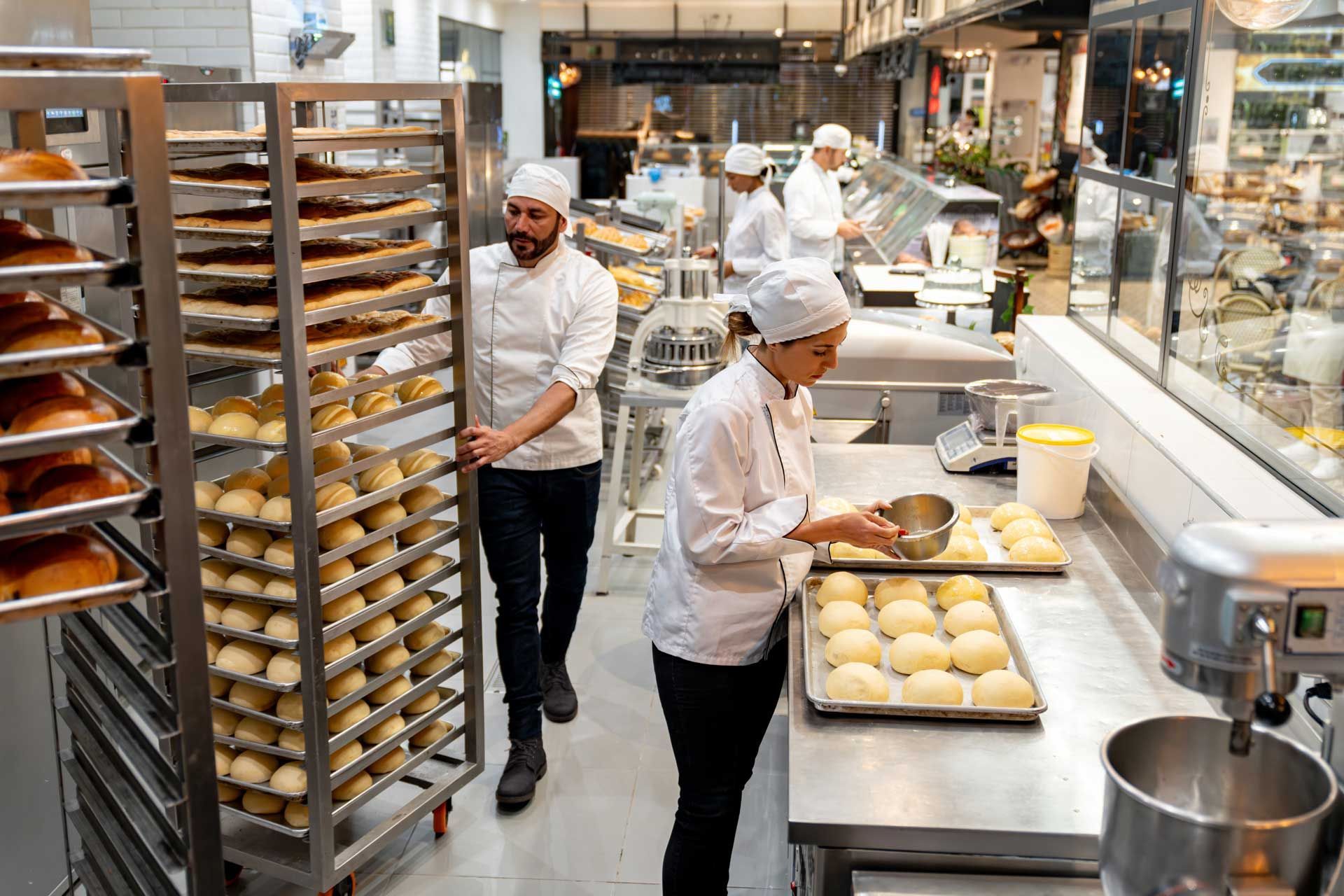 Group of employees working at a bakery baking bread.