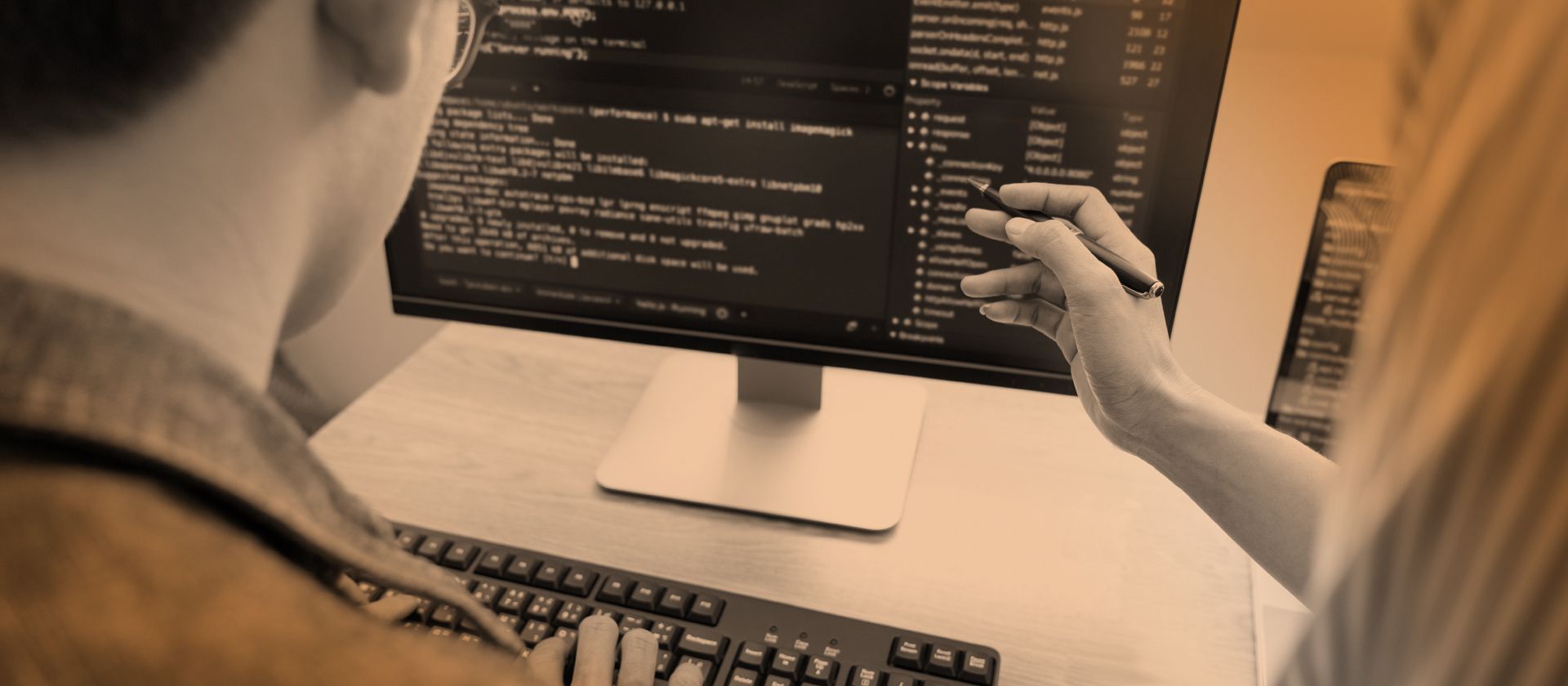 A man and a woman are looking at a computer screen.