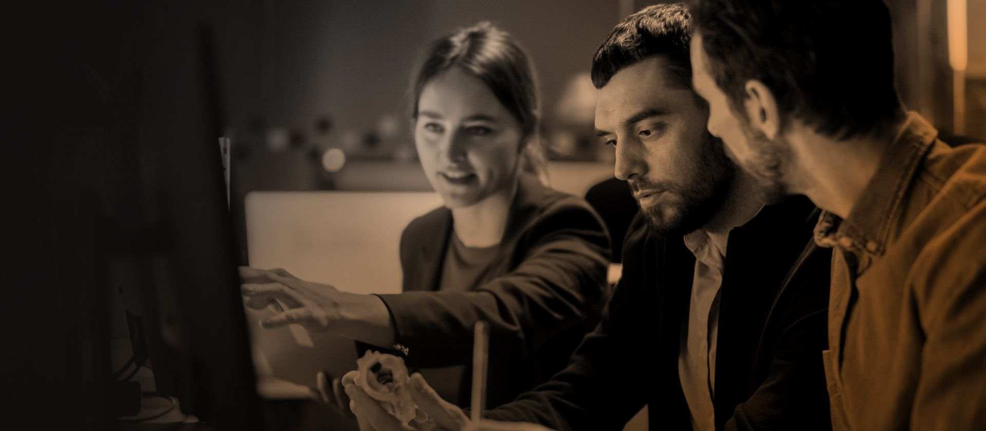 3 members of a cyber team looking at a computer screen