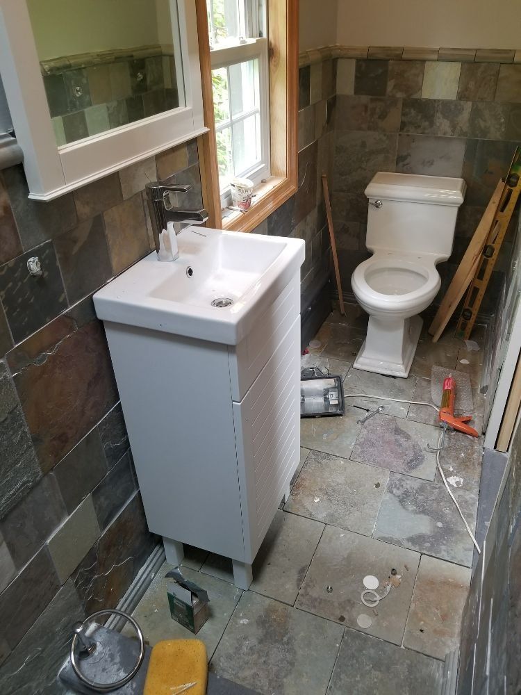 A bathroom with a sink , toilet and mirror.
