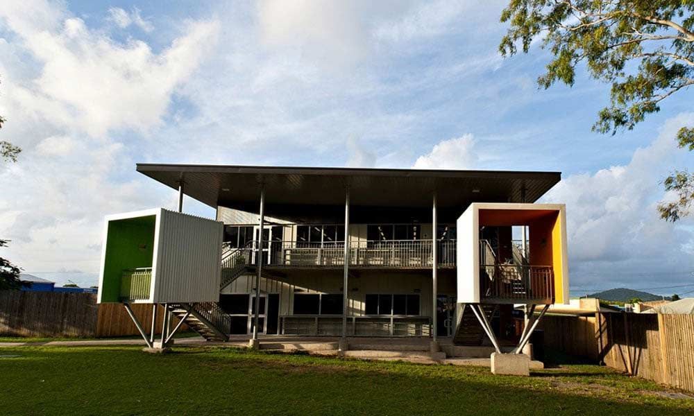 A Large House Is Sitting On Top Of A Lush Green Field — BOLD Architecture + Interior Design In Mackay, QLD