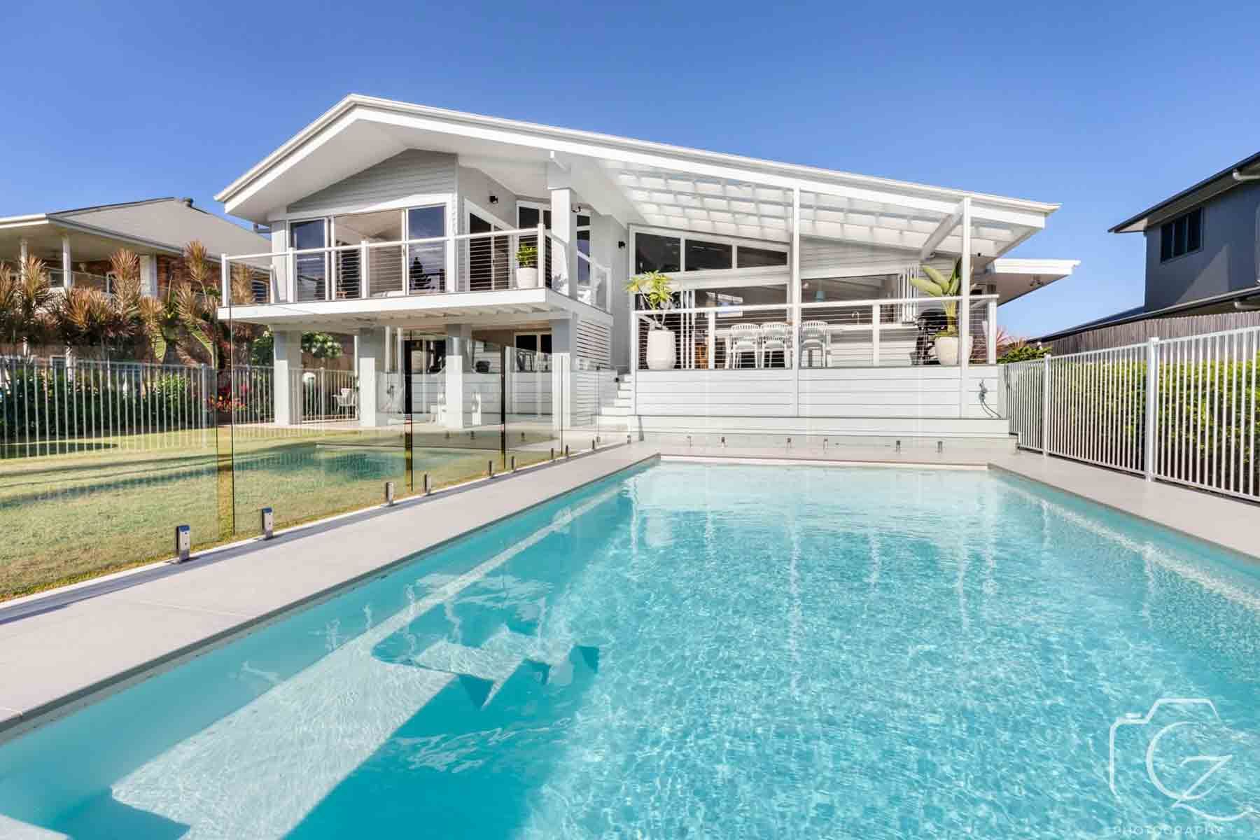A Large House With A Swimming Pool In Front Of It — BOLD Architecture + Interior Design In Mackay, QLD