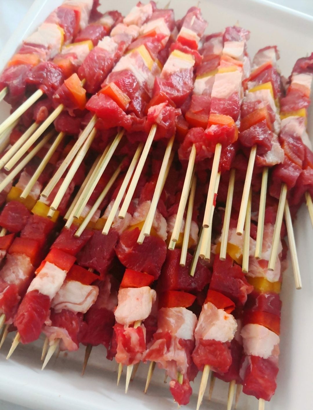 Roast beef affettato con salsa su un piatto bianco con posate.