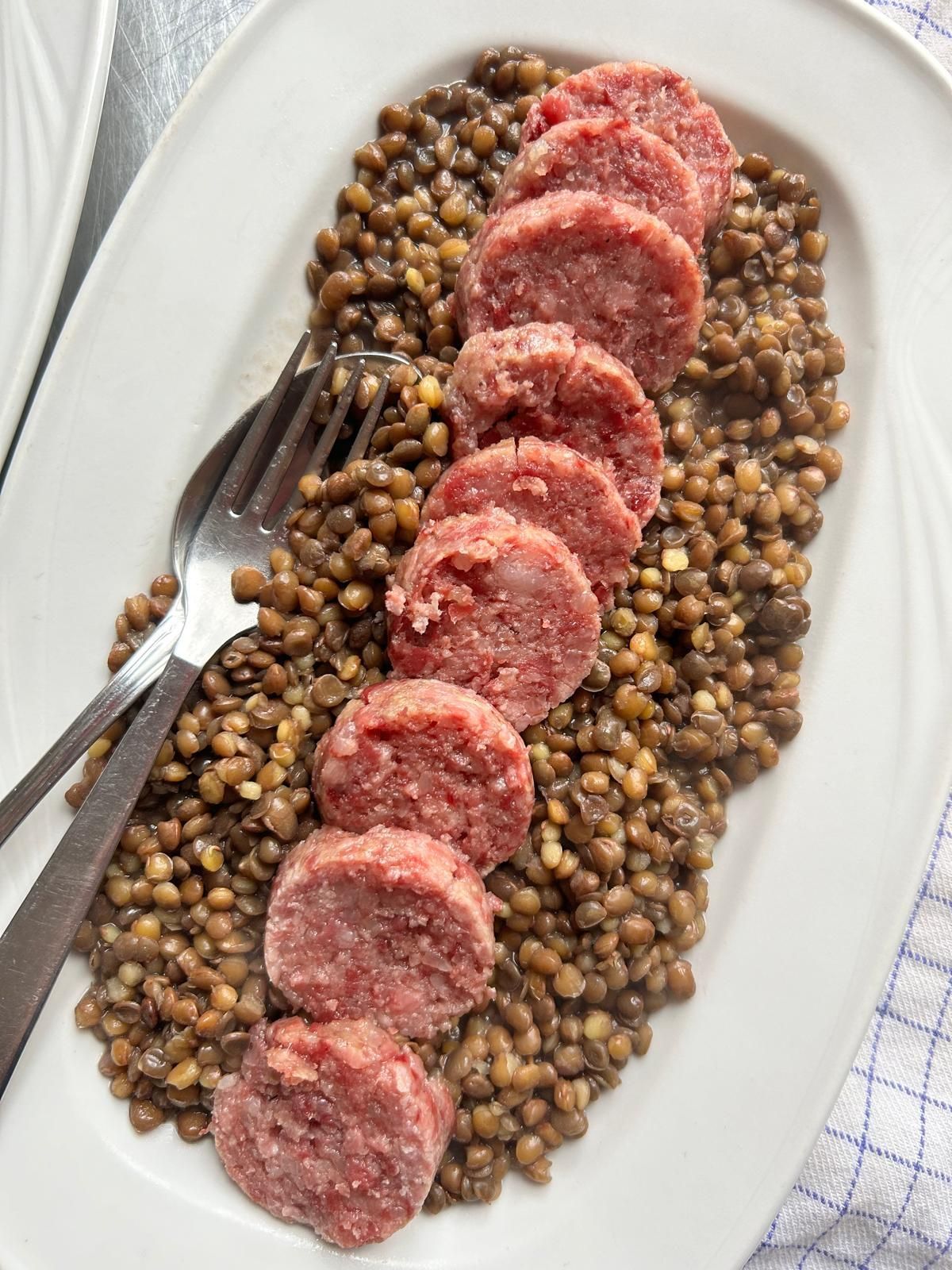 Salsiccia di mortadella a fette con cubetti bianchi e pistacchi verdi.