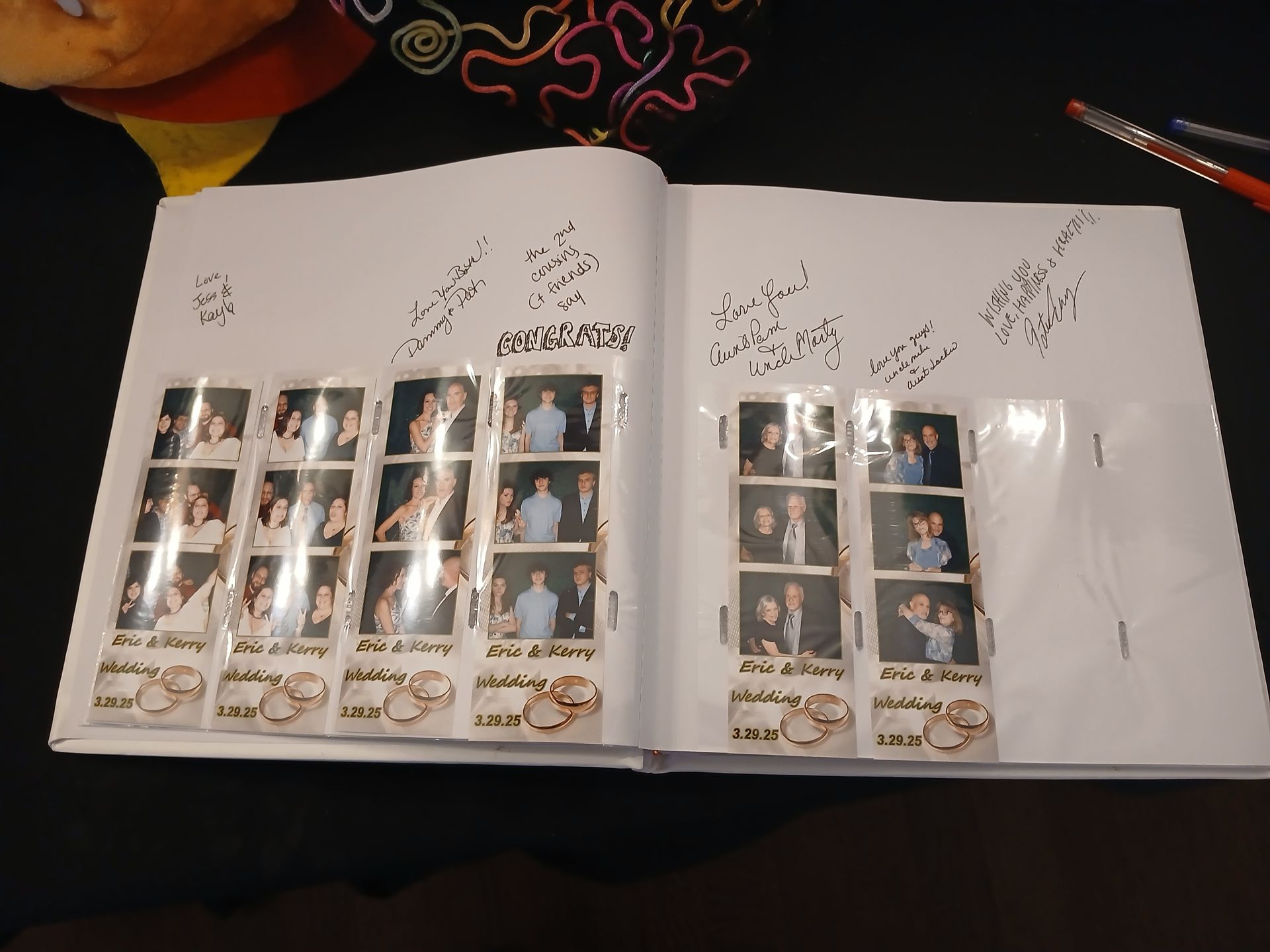 Photo booth strips in a scrapbook with signatures. Wedding theme with gold rings.