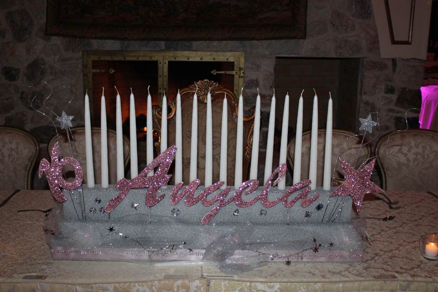 A centerpiece for a party table with candles spelling 