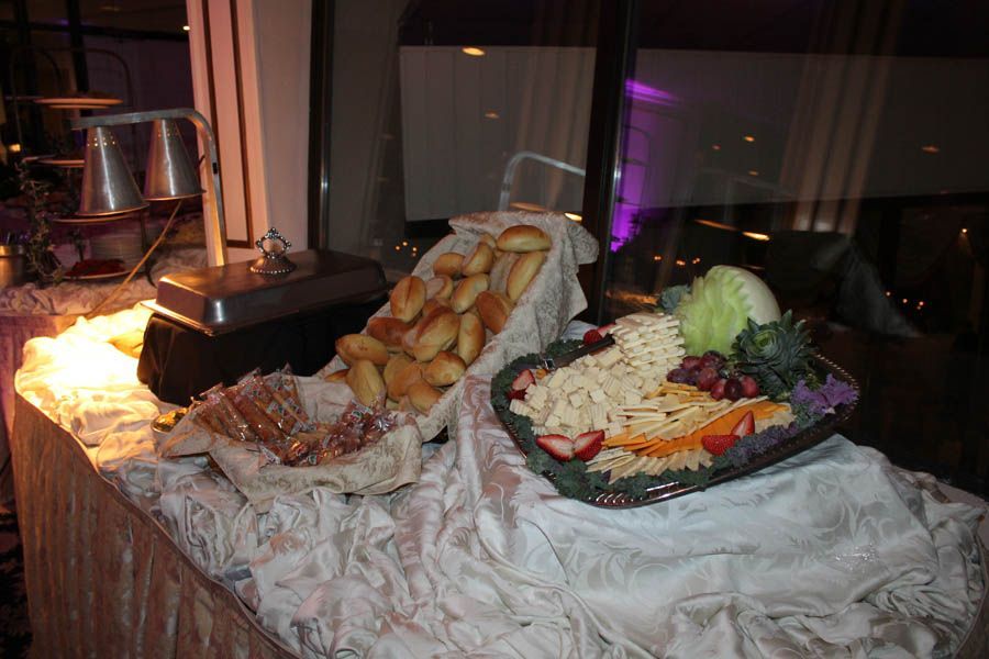 Buffet table with rolls, pasta salad, and warmers.