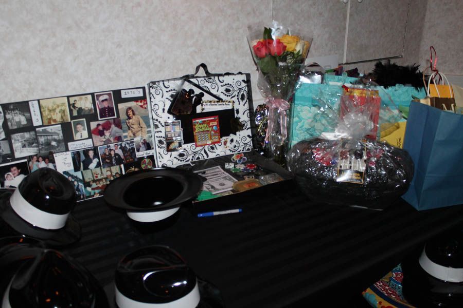 Table display with gifts, hats, flowers, and photos.