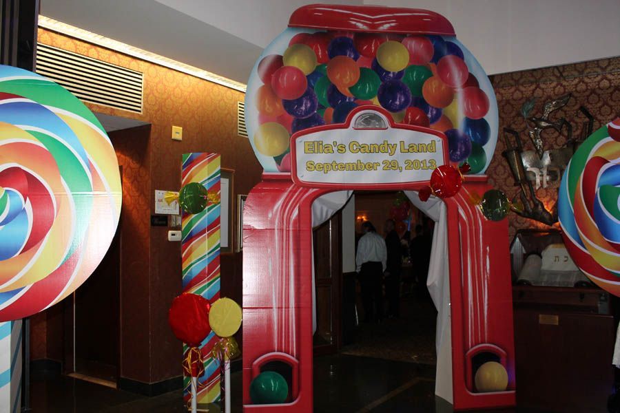 Candy Land themed entrance with giant gumball machine archway and lollipop decorations.